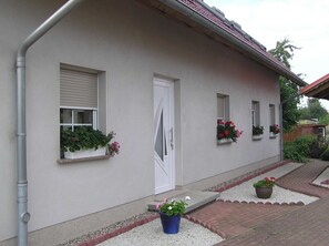 A building with a white exterior, a front door, and windows with flower boxes.