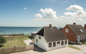A coastal property with a white building, a red-roofed structure, and a view of the sea. - Cozy home in Rudkøbing with WiFi (Rudkøbing)