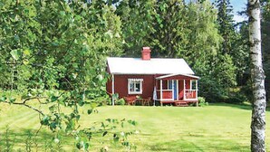 A red house with a white roof and a porch, surrounded by greenery. - Amazing home in Hagfors (Hagfors)