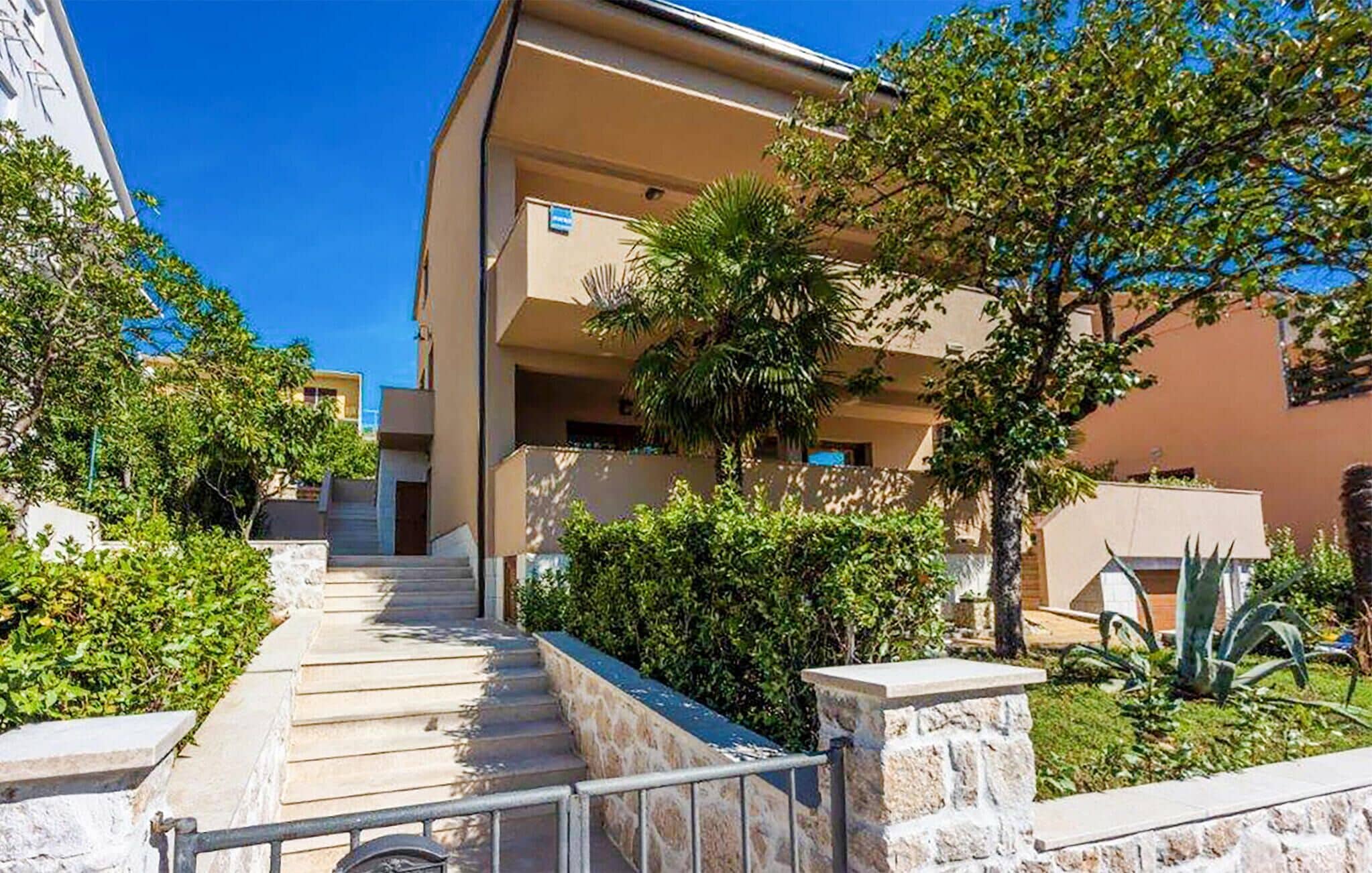 A multi-story building with a central staircase leading to the entrance.