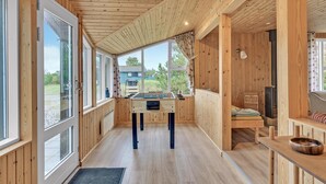 A wooden interior with a foosball table, a sofa, and a fireplace. - 3 bedroom lovely home in Sæby (Sæby)