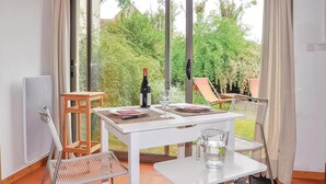 Een eethoek met een tafel gedekt voor twee personen, een wijnfles en een glas water.