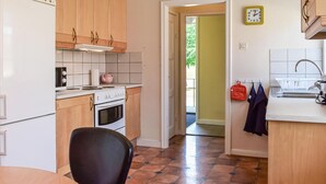 Une cuisine avec des meubles de rangement en bois, une cuisinière et un évier.