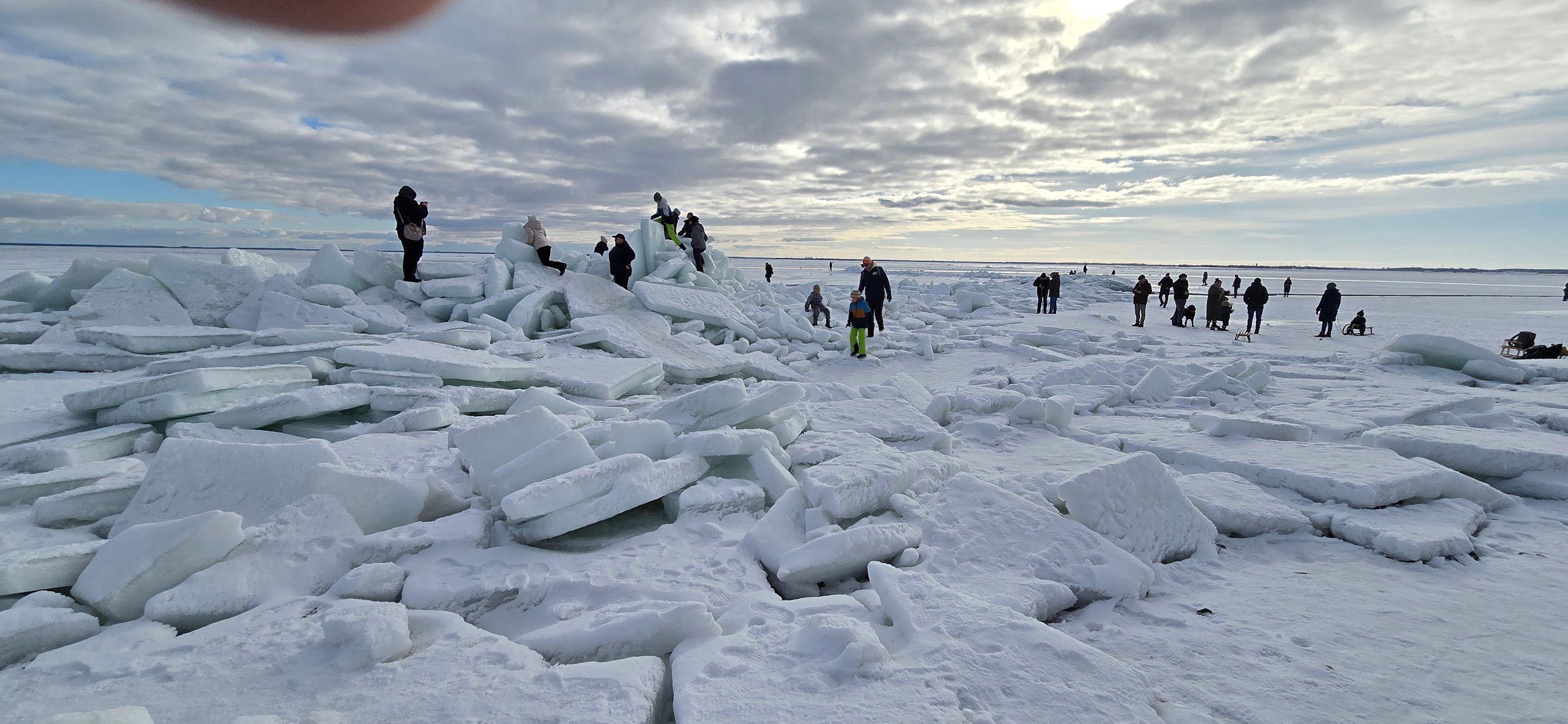 A snowy landscape with ice chunks and people.
