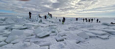 A snowy landscape with ice chunks and people.