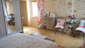 A bedroom with a bed, a dresser, a chair, and a small table with a vase of flowers. - Stunning home in RUFFEY LES BEAUNE (RUFFEY LES BEAUNE)