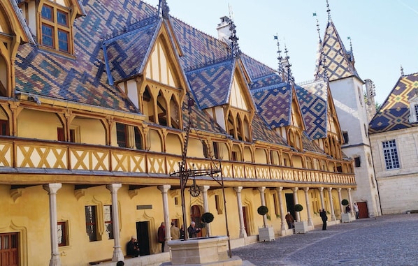 A historic building with a long facade, multiple gabled roofs, and a series of arched windows.