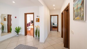 Ein Flur mit modernem Design, ausgestattet mit einem großen Spiegel, einem Willkommensschild und einem Gemälde an der Wand.