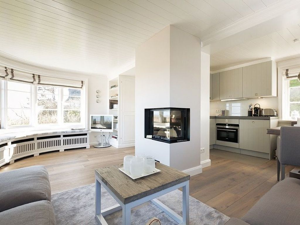 Ein modernes Wohnzimmer mit Fernseher, Couchtisch und Sofa.