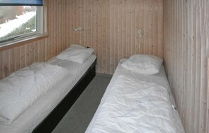 A room with two single beds, wooden walls, a window, and a view of the outside. - 3 bedroom cozy home in Rudkøbing (Rudkøbing)