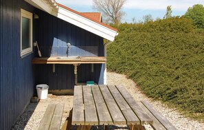 A wooden deck with a sink and a window, surrounded by gravel and a hedge. - 3 bedroom cozy home in Rudkøbing (Rudkøbing)
