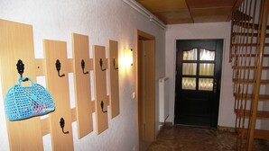 Ein Flur mit Holzwandverkleidung, einer Bank und einer Treppe.
