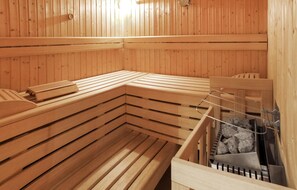 A sauna with wooden benches and a bench with a towel. - moderne Ferienwohnung st.Anton (St. Anton)