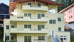 Un immeuble à plusieurs étages doté de balcons, d’un escalier et d’un espace extérieur couvert.
