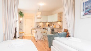 Una stanza moderna e luminosa, con angolo cottura, zona pranzo e un letto.