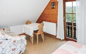 Enjoy a peaceful retreat with a view of lush greenery from the wooden-framed window.
