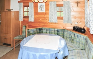 Cozy room with a round table, bench, and wooden cabinet.
