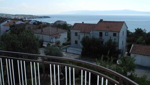 Ein Küstenwohngebiet mit Häusern, freiem Blick auf das Meer und einer entfernten Bergkette.