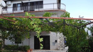 Ein zweistöckiges Gebäude mit Balkon und Steinverkleidung.