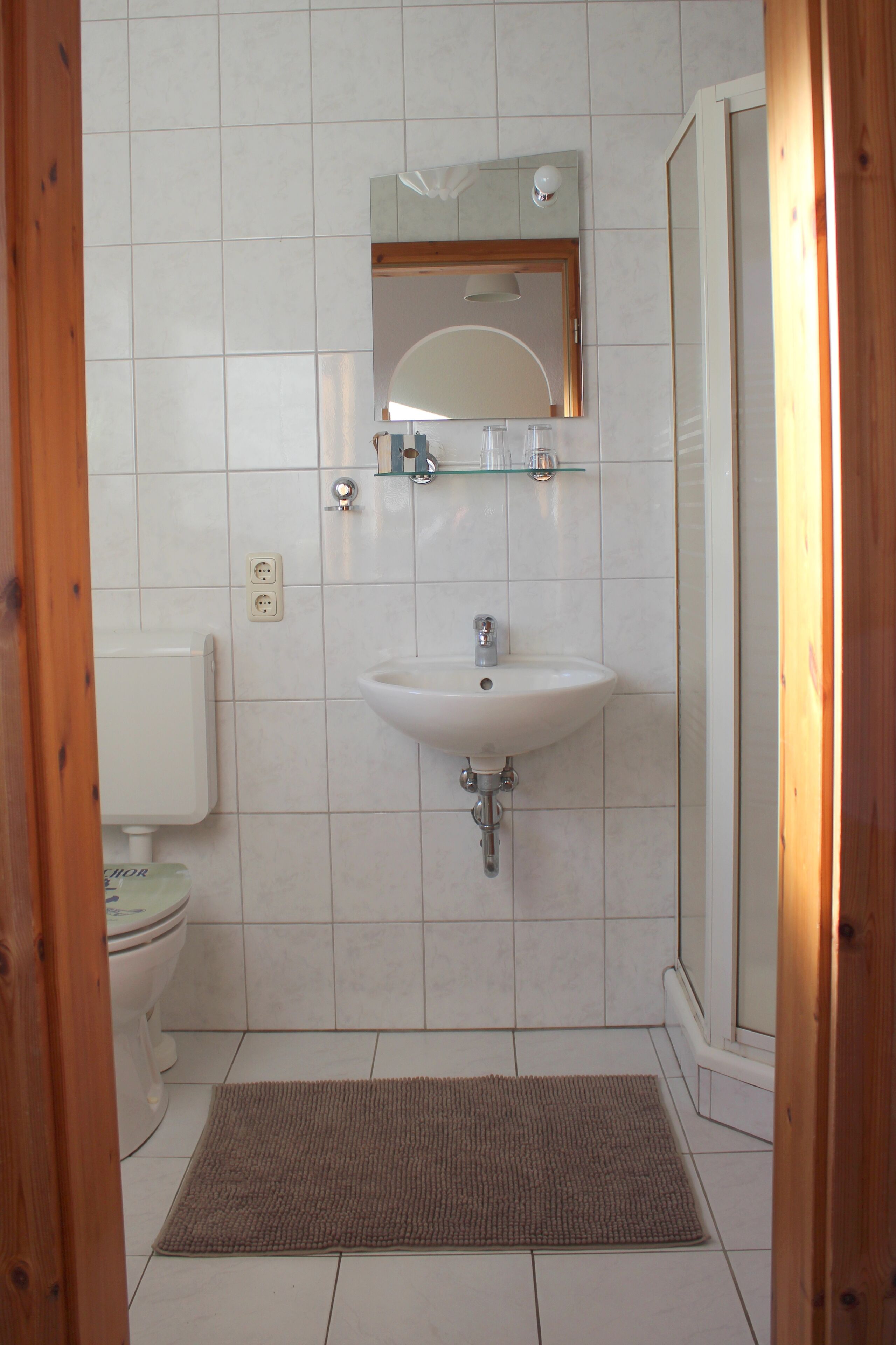 A bathroom with a white sink, mirror, and toilet.