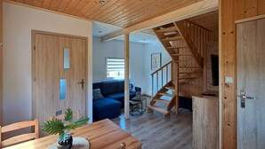 A wooden interior with a staircase, a sofa, and a dining area. - 2 bedroom lovely home in Podamirowo (Podamirowo)