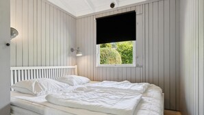 A bedroom with a bed, a window, and a wall-mounted lamp. - Amazing home in Tisvildeleje with WiFi (Tisvildeleje)