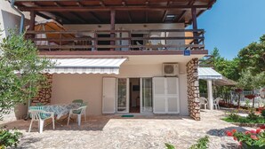 A two-story building with a balcony, a covered outdoor seating area, and a sign indicating it is an apartment. - Amazing apartment in Jadrija with WiFi (Jadrija)