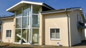 A modern building with a glass facade, a staircase, and a small balcony. - Apartment 07 - Haus Windrose: 2 Vacation Rentals in the Heart of Binz (Binz)