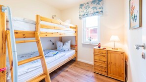A bunk bed room with a wooden desk and a window with a view. - Apartment 07 - Haus Windrose: 2 Vacation Rentals in the Heart of Binz (Binz)