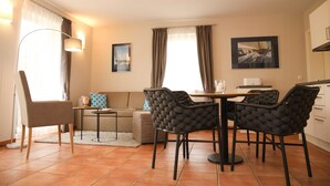 Una sala de estar moderna con un sofá, una mesa de comedor con sillas y una zona de cocina.