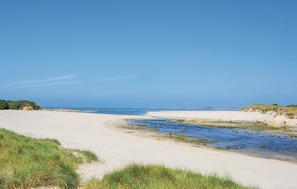 Une plage avec des dunes de sable et un ciel dégagé.