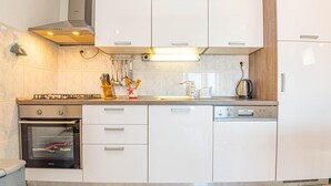 A modern kitchen with white cabinets, a built-in oven, and a gas stove.