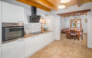 A modern kitchen with white cabinets, a built-in oven, and a patterned backsplash. - Nice home in Boduleri with private swimming pool, can be inside or outside (Boduleri)