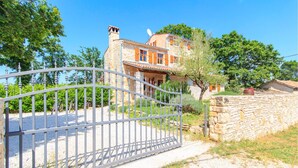 A stone house with a stone wall and a metal gate in front. - Amazing home in Boduleri (Boduleri)