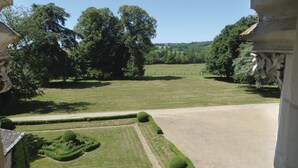 A formal garden with neatly trimmed hedges and a gravel path.