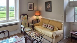 A cozy living room with a sofa, armchair, and a table with a lamp.