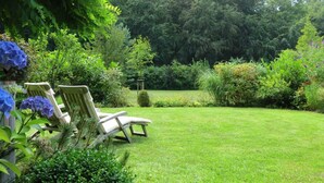 A well-maintained garden with a lawn, two lounge chairs, and a variety of plants and trees. - Herring Gull - Herring Gull (Heringsdorf)