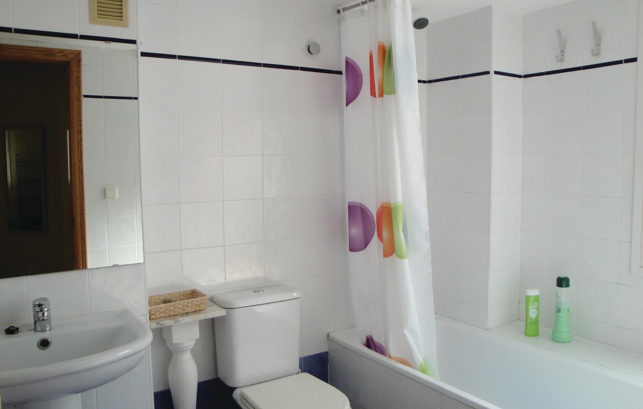Un baño con lavamanos, inodoro y bañera blancos.