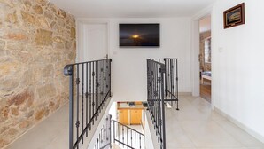 Una scala con un muro in pietra su un lato e una porta bianca in cima.