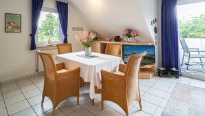 A dining area with a table, chairs, and a vase of flowers. - Reriker Straße RER20-02. - Reriker Straße 20 Whg. 02 (Kühlungsborn)