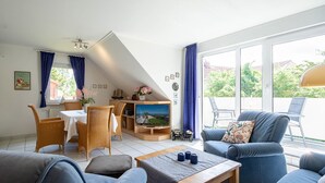 A spacious living room with a television, seating area, and a view of the outdoors. - Reriker Straße RER20-02. - Reriker Straße 20 Whg. 02 (Kühlungsborn)