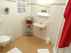 A bathroom with a toilet, sink, and shower curtain.