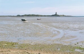 A beach with boats and a distant island with a tower. - Amazing home in Quettehou (Quettehou)
