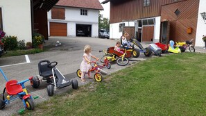 Kinderen spelen met speelgoedauto's op een oprit.