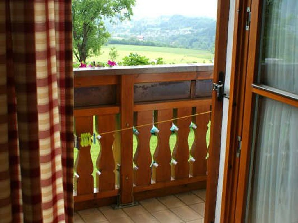 Ein Balkon mit Holzbalkon und Blick auf eine grüne Landschaft.