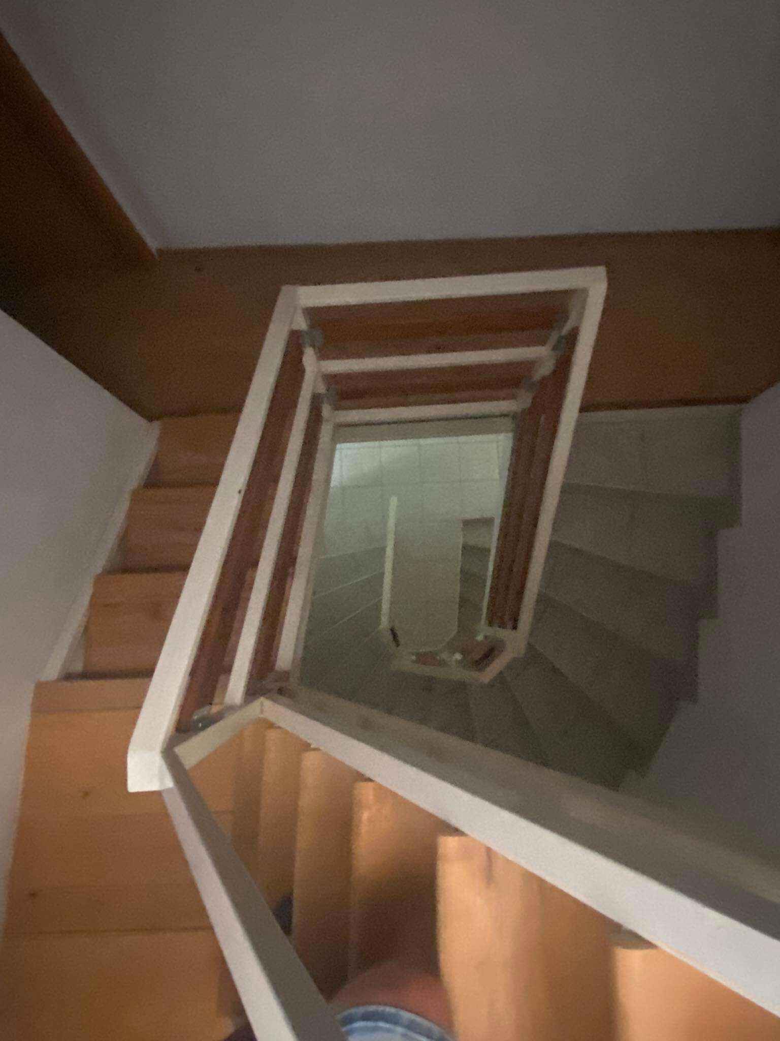 A wooden staircase with a small window at the top.