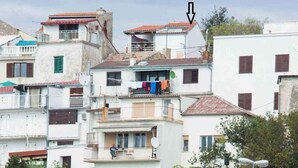 A coastal residential area with multi-story buildings, a stone wall, and boats docked near the water. - Holiday home with internet access and sea view (Novi Vinodolski)