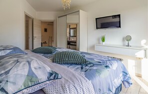 A bedroom with a bed, a TV, a desk, and a mirror. - Lovely home in Pula with sauna (Pula)