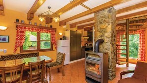 Una cucina accogliente con parete in pietra, travi in legno e stufa a legna integrata.