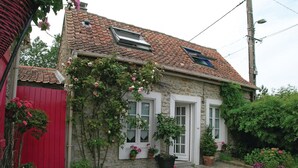 A stone building with a tiled roof, two windows, and a red door. - Amazing home in Ambleteuse with WiFi (Ambleteuse)
